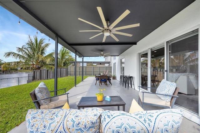 view of patio featuring a ceiling fan, a fenced backyard, a water view, an outdoor living space, and outdoor dining space