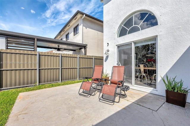 view of patio / terrace featuring ceiling fan and fence