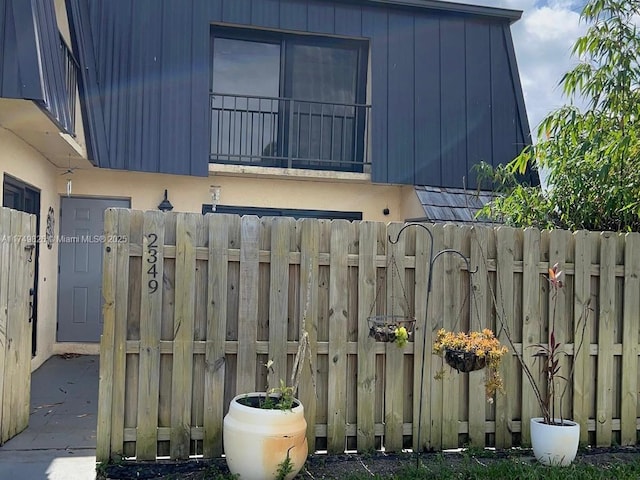 view of side of property featuring fence and a balcony