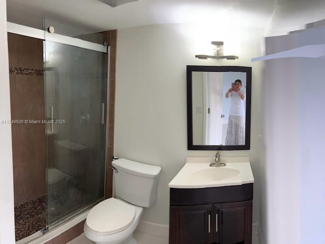 bathroom with toilet, a shower stall, and vanity