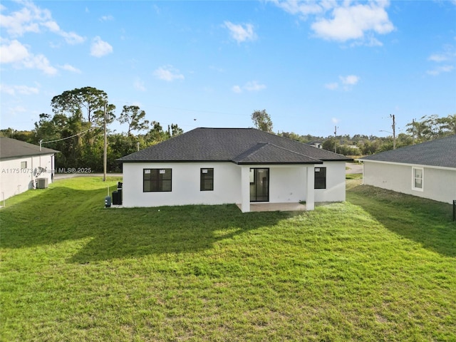 back of property featuring a patio, a shingled roof, a lawn, and central AC unit