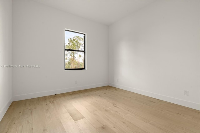 spare room featuring light wood-style flooring and baseboards