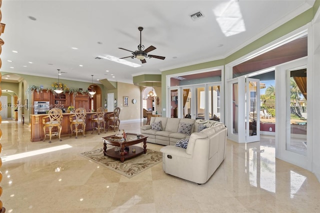 living area featuring arched walkways, visible vents, marble finish floor, french doors, and ornamental molding