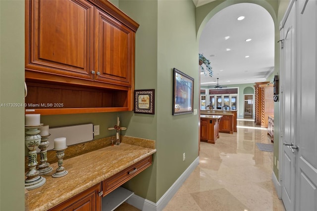 hall with baseboards, arched walkways, and recessed lighting