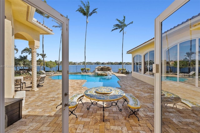 view of swimming pool featuring a patio, a water view, and a fenced in pool