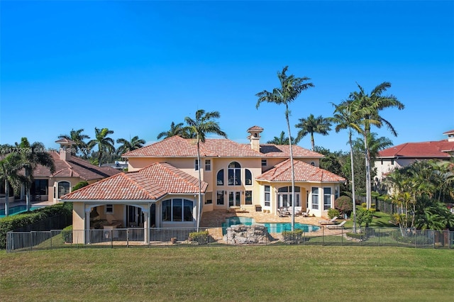 back of property featuring a fenced in pool, a fenced backyard, a yard, and stucco siding