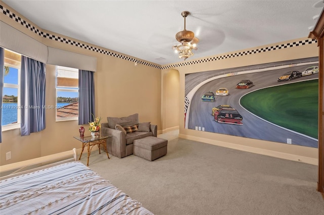 carpeted bedroom with ceiling fan with notable chandelier, a water view, and baseboards