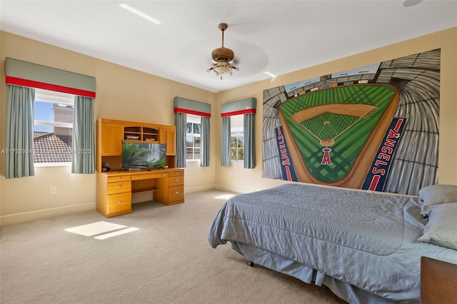 bedroom featuring multiple windows, light carpet, and baseboards