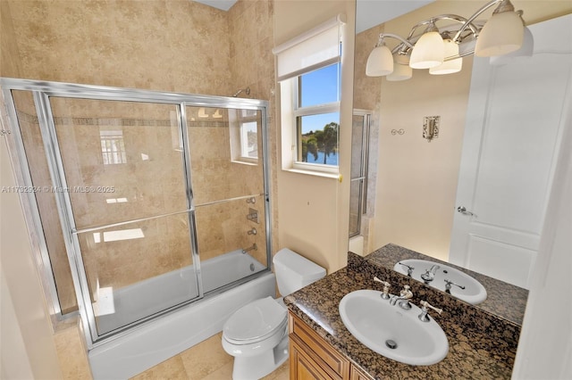 full bath featuring shower / bath combination with glass door, tile patterned flooring, vanity, and toilet