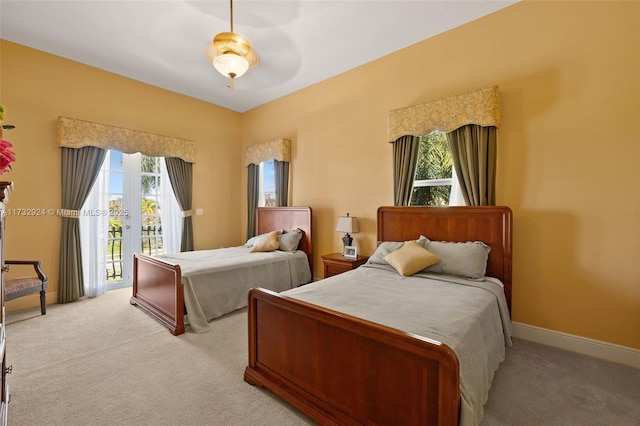 bedroom featuring light carpet, baseboards, a ceiling fan, and access to exterior