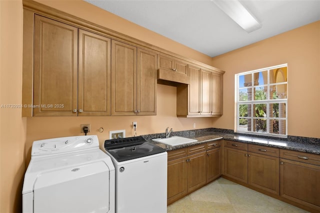 clothes washing area with cabinet space, washer and clothes dryer, and a sink