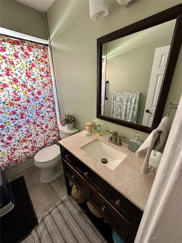 full bathroom with toilet, curtained shower, and vanity