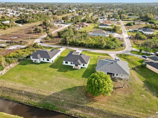 drone / aerial view featuring a residential view and a water view