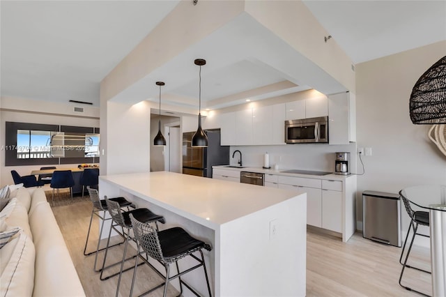 2000 Island Blvd Unit 3010, Aventura, FL 33160 - kitchen featuring appliances with stainless steel finishes, a breakfast bar area, open floor plan, modern cabinets, and white cabinets
