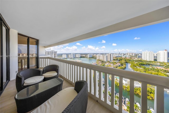 balcony featuring a water view and a city view