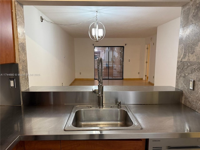 kitchen with light countertops, decorative light fixtures, a sink, and a notable chandelier