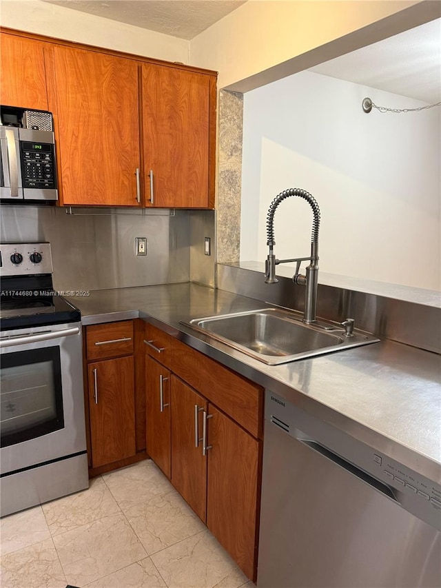 kitchen with marble finish floor, stainless steel appliances, and brown cabinetry