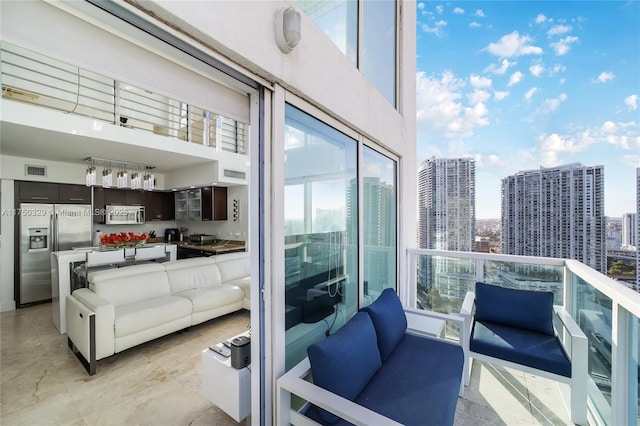 balcony featuring an outdoor living space, a city view, and visible vents