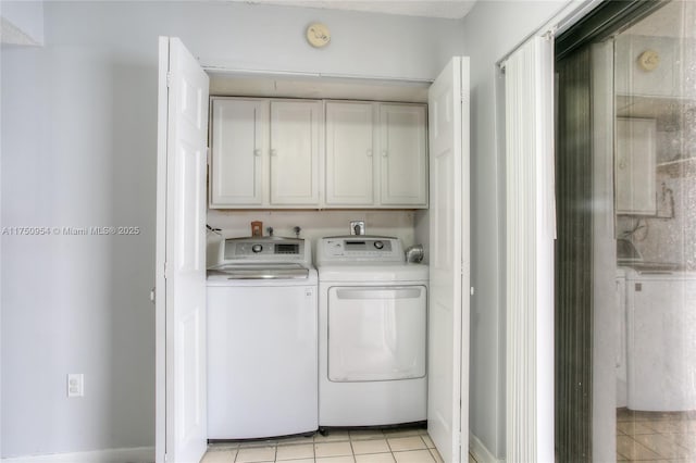 laundry room with light tile patterned floors, washer and clothes dryer, and cabinet space