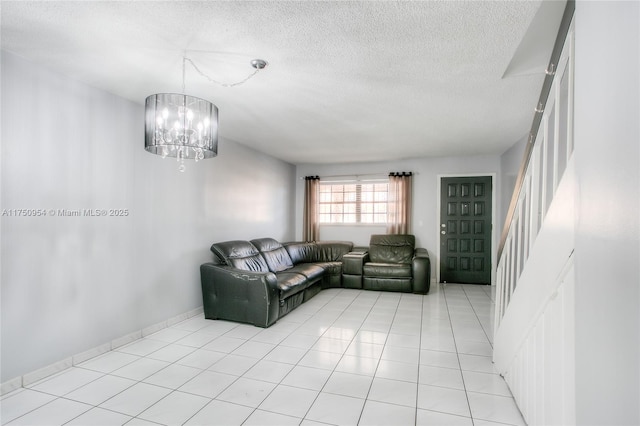 living area with a textured ceiling, a chandelier, light tile patterned flooring, baseboards, and stairway