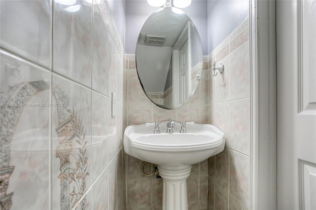 bathroom with visible vents and tile walls