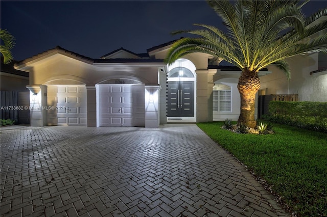 surrounding community featuring a garage, decorative driveway, and a yard