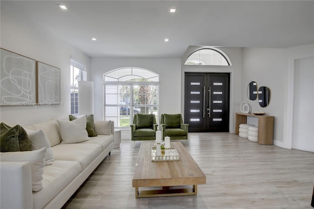 living room with light wood-type flooring and recessed lighting