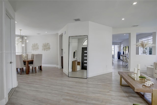 corridor featuring light wood-style floors, baseboards, visible vents, and recessed lighting