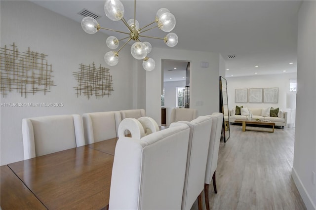 dining room with light wood-style floors, recessed lighting, visible vents, and a notable chandelier