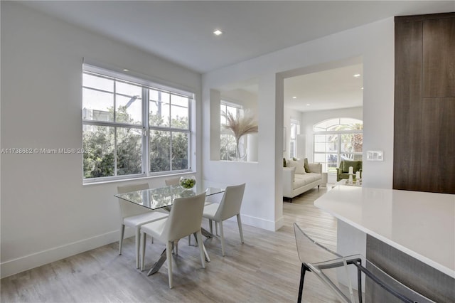 dining room featuring light wood-style flooring, baseboards, and recessed lighting