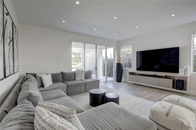 living room featuring light wood finished floors, baseboards, and recessed lighting