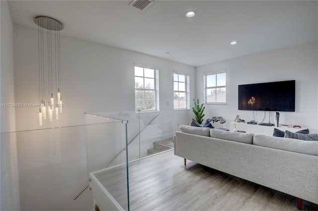 living room with light wood-style flooring, visible vents, and recessed lighting