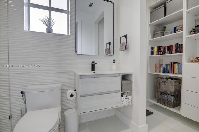 bathroom with toilet, visible vents, tile walls, and vanity