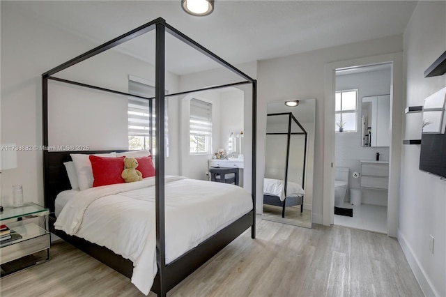 bedroom featuring light wood-type flooring, multiple windows, and baseboards