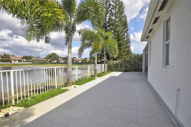 view of patio / terrace featuring a water view and a fenced backyard