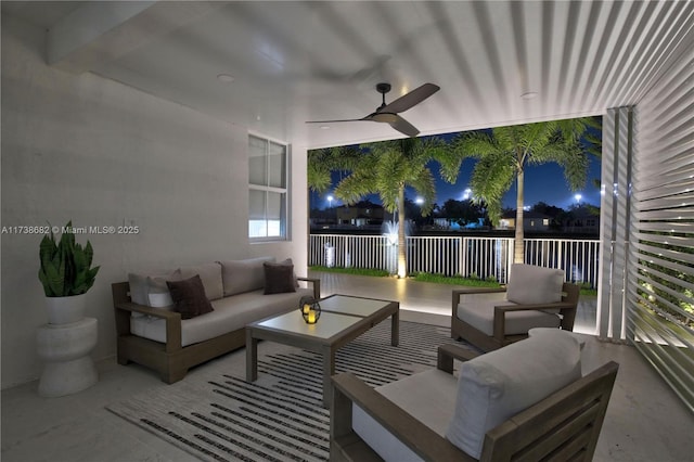 patio at night with ceiling fan and an outdoor living space