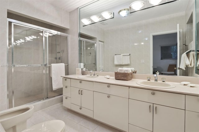 ensuite bathroom with tile patterned flooring, a closet, a bidet, and a sink