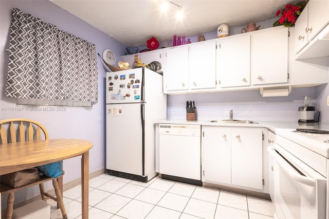 kitchen with white appliances, white cabinets, light countertops, a sink, and light tile patterned flooring