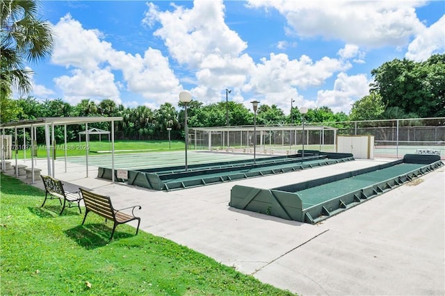 view of property's community featuring a lawn and fence