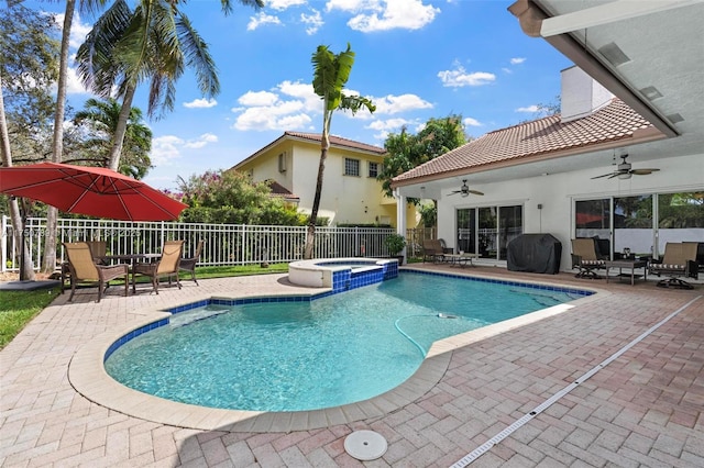 view of pool with a pool with connected hot tub, a patio area, a fenced backyard, and a ceiling fan