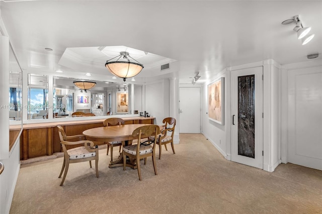 dining area featuring ornamental molding, a tray ceiling, and visible vents