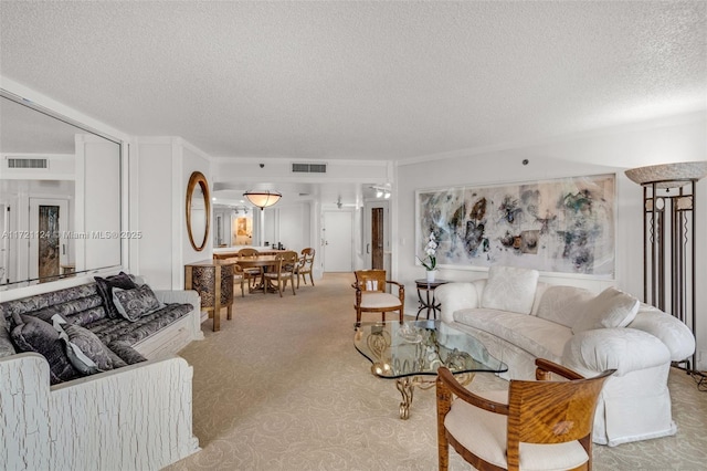 living room with light carpet, visible vents, and a textured ceiling