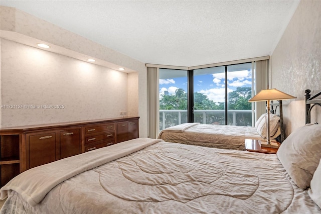 bedroom featuring expansive windows, a textured ceiling, and recessed lighting