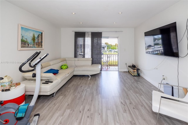 exercise room with recessed lighting, baseboards, and light wood finished floors