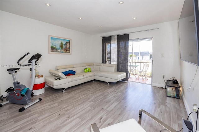 workout area featuring light wood-style floors, recessed lighting, and baseboards