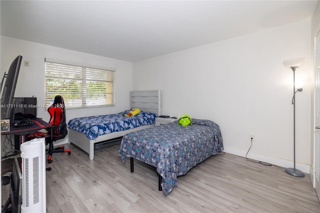 bedroom with light wood-style flooring and baseboards