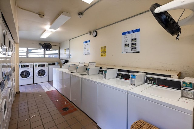 shared laundry area with washer and dryer and dark tile patterned flooring