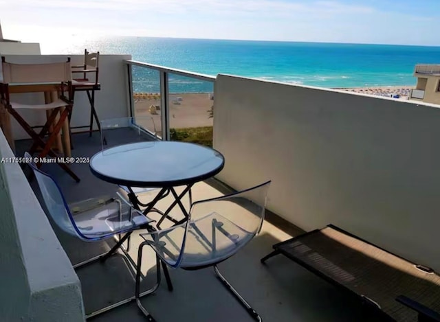 balcony featuring a water view and a beach view