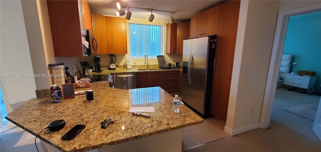 1945 S Ocean Dr Unit 701, Hallandale Beach, FL 33009 - kitchen featuring a sink, light stone counters, a peninsula, appliances with stainless steel finishes, and brown cabinets