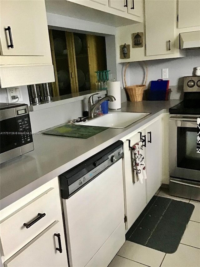 kitchen featuring light countertops, appliances with stainless steel finishes, white cabinets, a sink, and under cabinet range hood